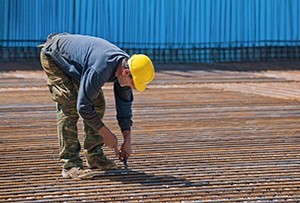 Construction working bending down to fix something